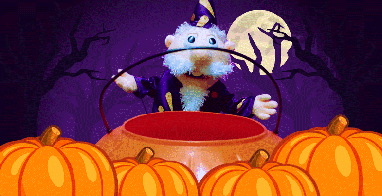 A puppet of a cartoon wizard standing behind a plastic orange pumpkin.